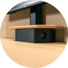 A small black power box on a desk with two outlets and a round knob.